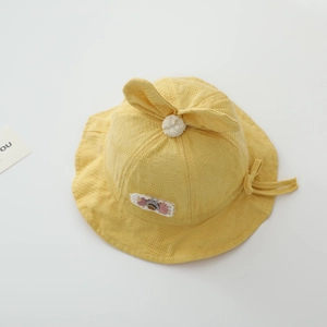 Detail of yellow waffle-knit baby sun hat with cute rabbit ears and chin strap
