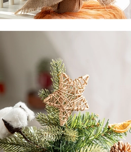 Close-up of natural straw stars, pine cones, and dried orange slices on a Christmas tree