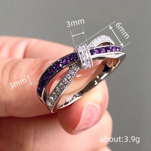 Elegant silver bow ring with purple gemstones and white pavé crystals on a model's hand