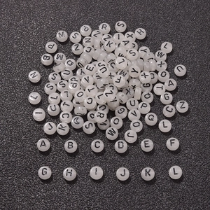 Luminous round alphabet beads 7x4mm for DIY crafts on a black textured background