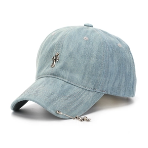 Detail of silver metal cross charms on a light blue washed denim baseball cap texture