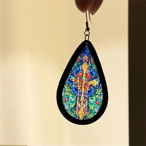 Macro detail of teardrop earring featuring stained glass cross pattern on acrylic