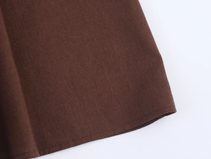Detail shot of deep brown cotton linen dress hem with high-quality double stitching