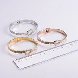 Sparkling crystal bangles in gold, silver, and rose gold with teardrop clasp and ruler scale