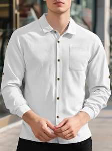 Close-up of men's white linen shirt texture with dark wood buttons and chest pocket detail