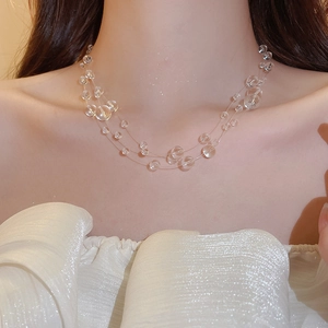 Macro view of multi-layer clear beaded necklace featuring irregular glass beads on a model