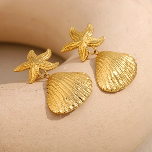 18K gold plated ocean starfish and shell drop earrings on a ceramic display