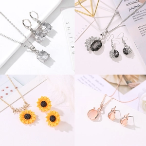 Details von vier Schmucksets mit funkelnden Kristallen, Perlen und floralen Mustern