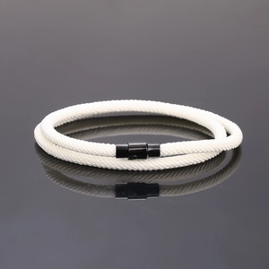 Detail of white double-layered braided rope bracelet with black magnetic clasp