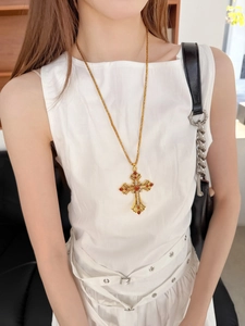 Gros plan détaillé du pendentif croix vintage en or avec gemmes rouges et diamants