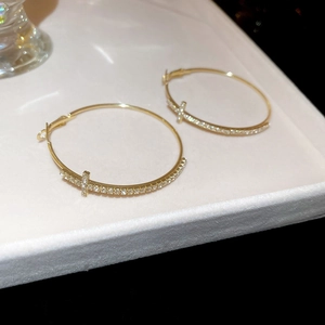 Détail macro de créoles dorées avec diamants scintillants sur un plateau à bijoux
