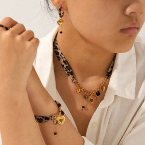 Gold heart jewelry set with leopard print fabric and black gemstones on white shirt