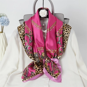 Pink silk square scarf with leopard print and gold chain detail on white shirt