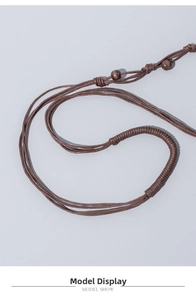 Dettaglio del cordino intrecciato a mano marrone scuro con perla in legno e nodi
