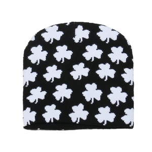 Détail du motif jacquard trèfle blanc sur un bonnet d'hiver en tricot noir chaud