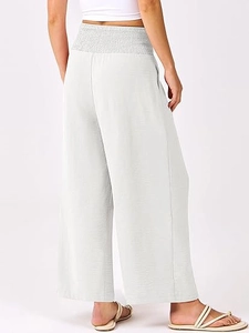 Détail de la taille haute élastique froncée sur le pantalon large gris clair