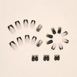 Sparkly black and nude pink V-shaped French press-on nails with golden glitter accents