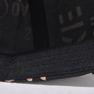 Detail of baseball cap brim with parallel stitching and patterned inner lining fabric