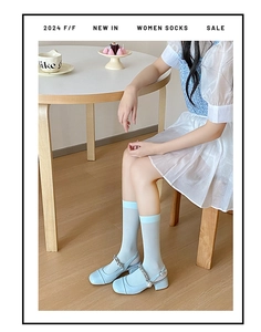 Close-up of thin blue velvet crew socks paired with matching blue Mary Jane shoes