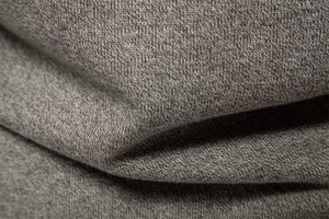Macro shot of high-quality taupe melange knit fabric texture with soft draped folds