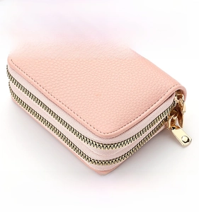 Detail view of pink litchi grain leather card holder with dual golden zippers