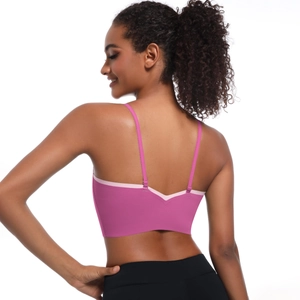 Detail of fuchsia sports bra featuring thin straps and contrast light pink trim on deep V back