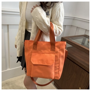 Orange nylon shoulder bag with front flap pocket and adjustable strap for daily commute