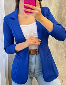 Detalle de chaqueta azul brillante para mujer con solapas clásicas y mangas dobladas