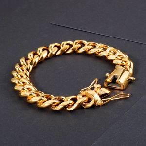 Detail of gold Cuban link bracelet showing the thick metal chain texture and dragon clasp