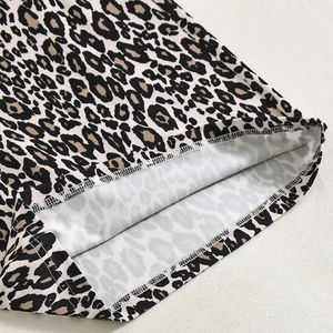 Detail shot of leopard print fabric showing fine white overlock stitching and high-quality hem