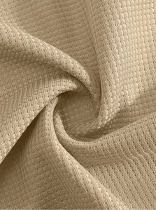 Gros plan sur la texture du tissu gaufré kaki montrant la qualité des coutures et du matériau