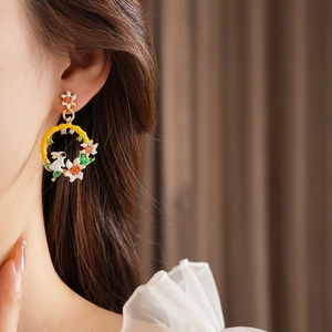 Gros plan d'une boucle d'oreille lapin vintage en émail sur l'oreille d'un mannequin