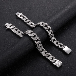 Detail of silver Cuban chain bracelet with micro diamonds and engraved clasp on black background