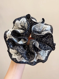 Gros plan détaillé d'un chouchou floral avec dentelle blanche et texture en tissu doux