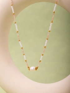 Dettaglio della collana di perline con pietre naturali rosa e grande perla barocca