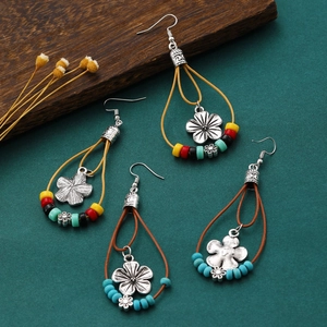 Detail of bohemian drop earrings with turquoise beads and alloy flower charms