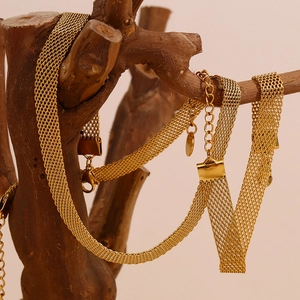 Detailed view of 18K gold plated mesh choker necklace draped on a dark wood stand