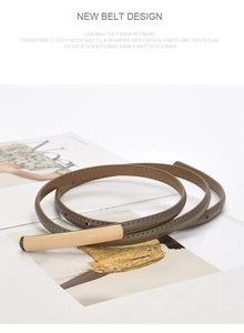 Close-up of a slim brown leather belt with a golden buckle on fashion magazines