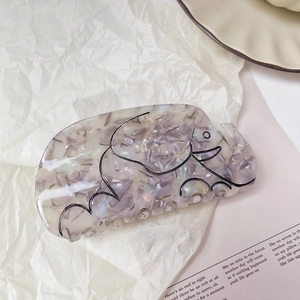 Détail de la pince à cheveux éléphant en acétate avec une finition irisée violette
