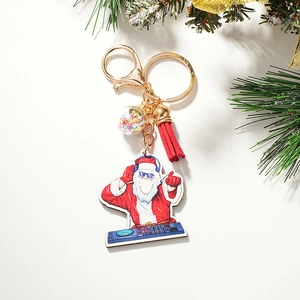Creative DJ Santa Claus keychain with red tassel and sequin ball on festive pine background