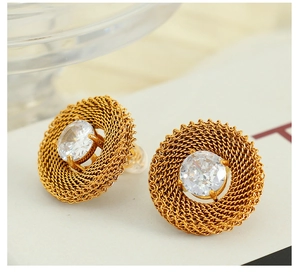 Macro shot of gold woven mesh stud earrings with a large clear round zircon center