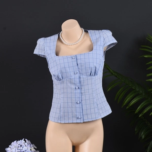 Detail of light blue plaid blouse showing square neckline and fabric-covered buttons