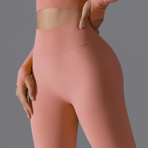 Detail of coral seamless high-waist yoga pants and long sleeve crop top with thumb holes