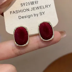 Detail of red flocked oval earrings with gold metal edges and S925 silver posts