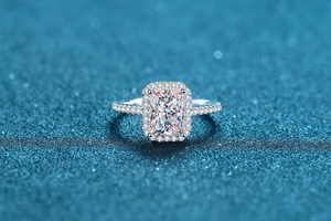 Macro detail of radiant cut moissanite ring with halo setting and pavé diamonds