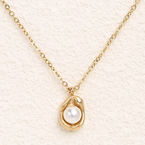 Elegant gold necklace with unique irregular metal pendant and white round pearl inlay