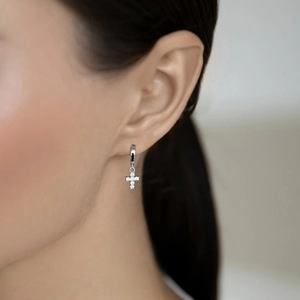Macro side view of silver sterling cross earrings with shimmering white zircon stones