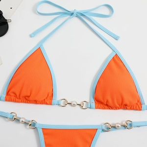 Détail du bikini orange avec bordure bleue, texture côtelée et mors doré avec perle