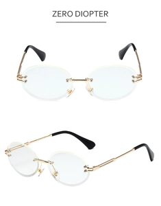Detail of rimless glasses featuring gold metal frames, black temples, and clear lenses