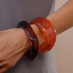 Irregular resin bangles in deep reddish brown and amber orange with retro geometric style